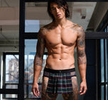 A model wearing navy blue Kinkilt briefs sitting in a cozy living room background