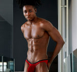 Model wearing red Starr briefs looking at the camera in a modern living room setting
